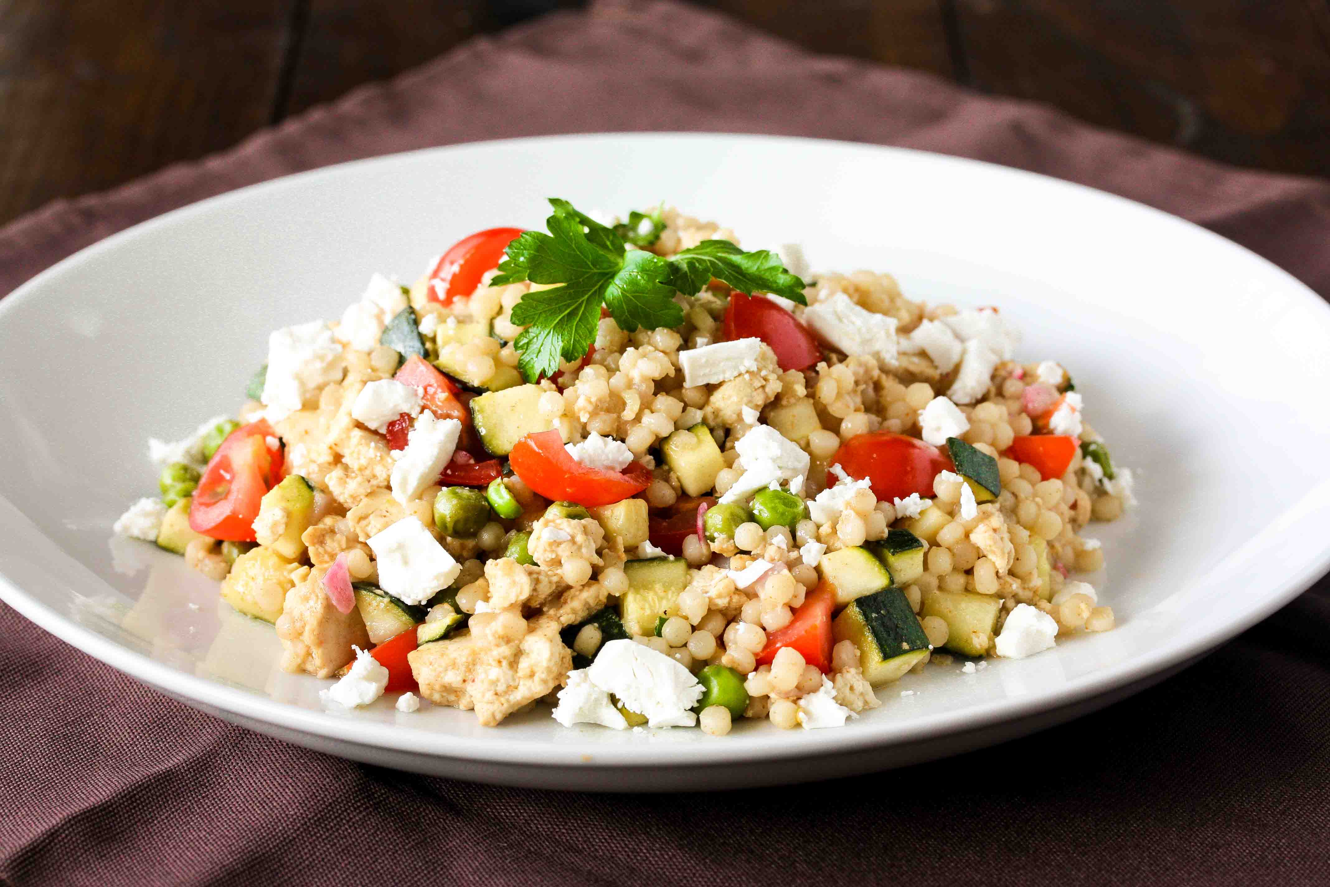 Smoky lemon tofu and pearl cous cous salad with zucchini, tomato and feta